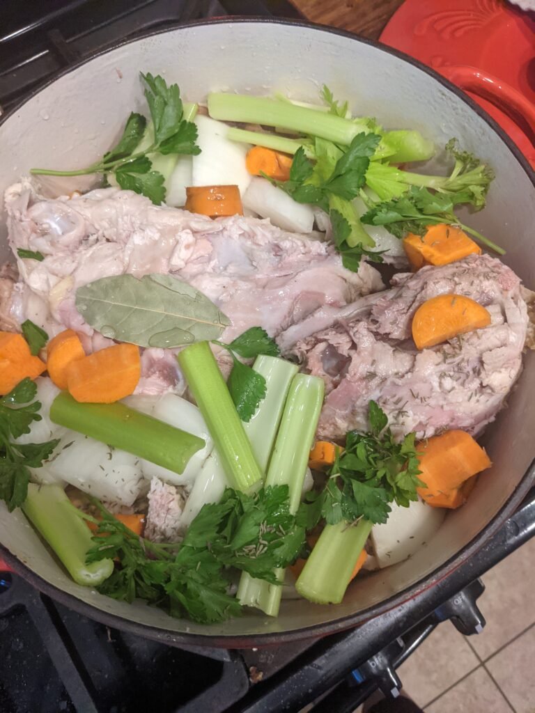 7 quart enameled coated cast iron dutch oven pot with boiled chicken and veggies for dinner