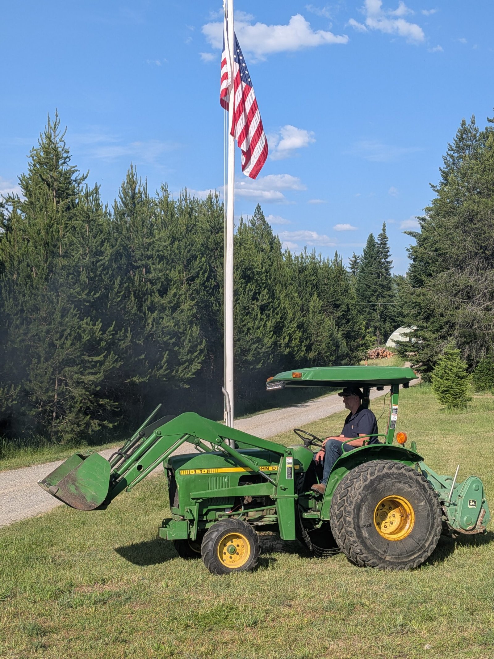 John Deer tractor on our homestead in front of an American flag.