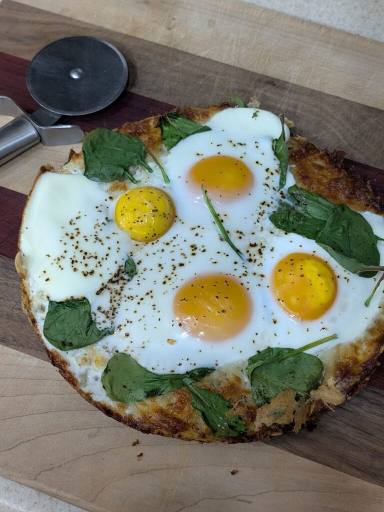 Homemade sourdough breakfast pizza with eggs and spinach