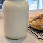 A gallon glass jar with fresh raw milk