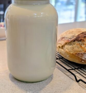 A gallon glass jar with fresh raw milk