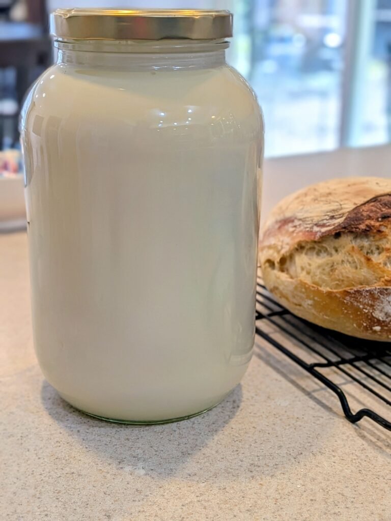 A gallon glass jar with fresh raw milk