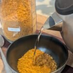 An instant kettle of hot water being poured into a bowl of freeze dried tomato soup