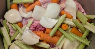 A large stainless steel stock pot with homemade chicken bone broth