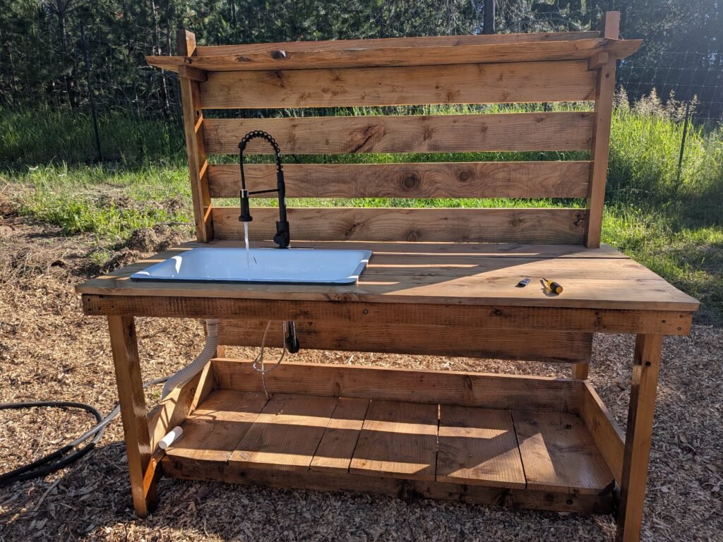Homemade potting table with cast iron sink and running water