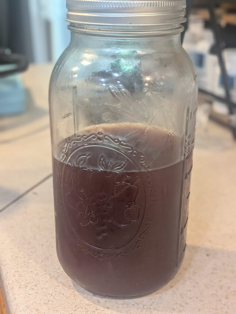 Half gallon mason jar full of cherry pit vinegar